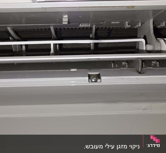 חלק פנימי של מזגן עילי פתוח עם הצטברות עובש ולכלוך